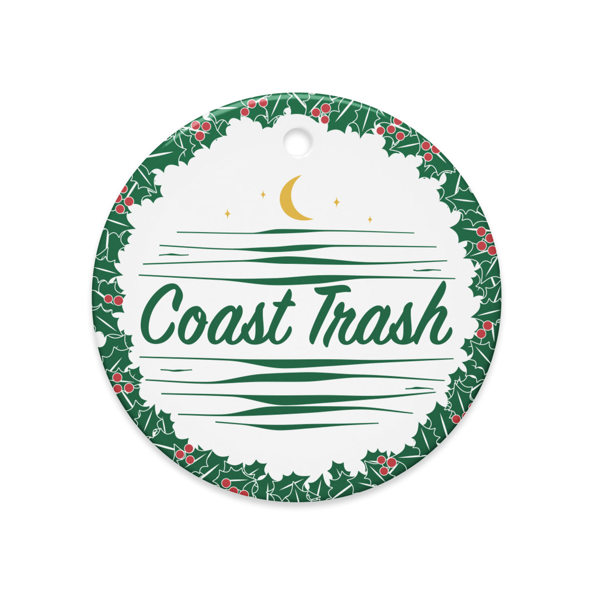 Front of A Festive Contribution ceramic ornament with a green holly wreath, red berries, Coast Trash script, waves and a gold crescent moon.